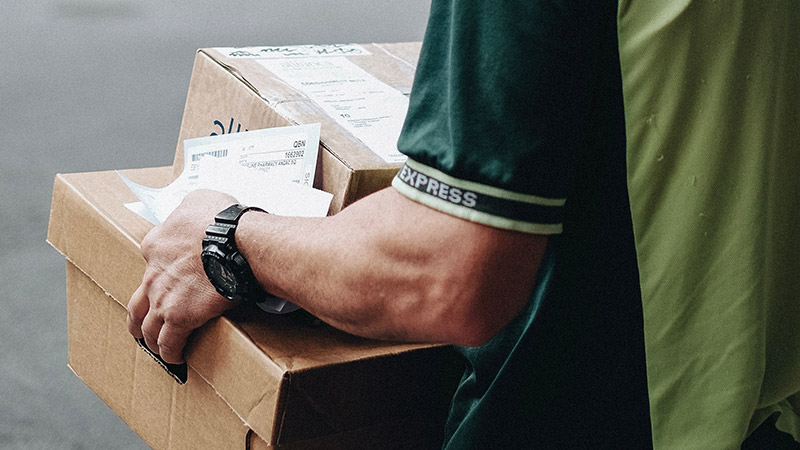 Man carrying boxes and mail