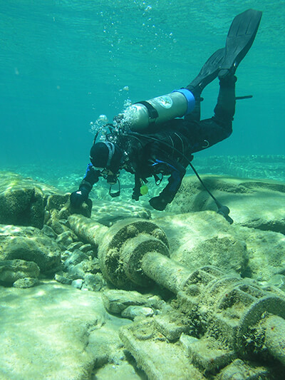 a diver grabs on to a piece of a shipwreck