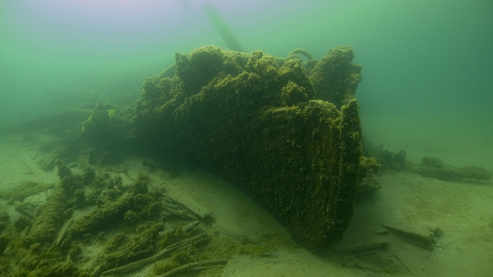 a shipwreck rest on a sandy lakebed