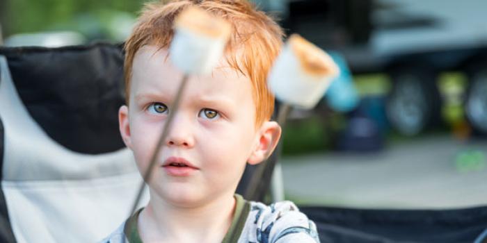 child with two marshmellows on a stick