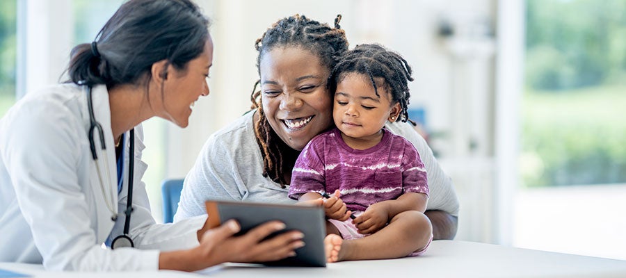 Health Equity as an Imperative. A Black mother with here child discusses test results with a clinician during a medical appointment.