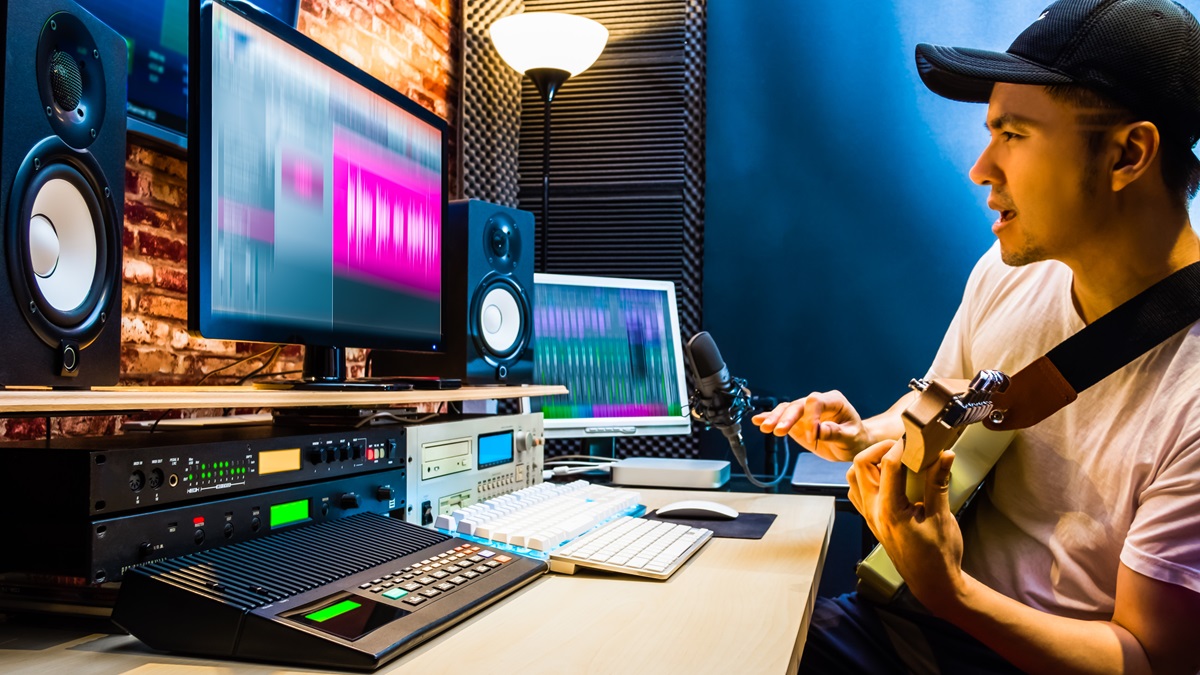 A guitarist records music in a studio.