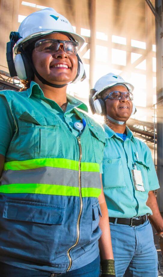 Two Vale employees, one man and one woman, are wearing safety equipment, such as vest, glasses and helmet.