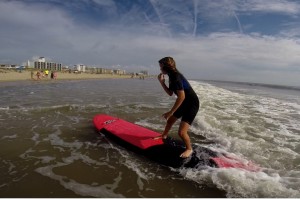 girl standing on surfboard in shallow water