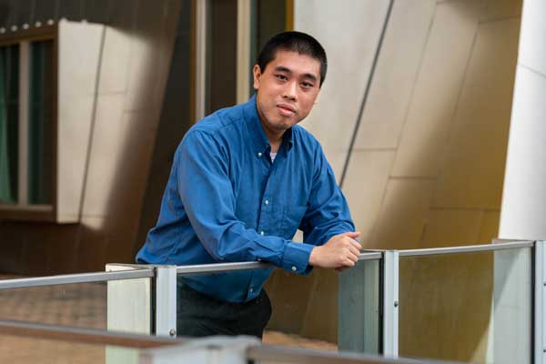 Julian Shun outside Stata and leaning on railing