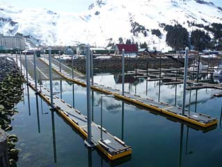 Whittier harbor boat launch area with snow covered mountains in background.