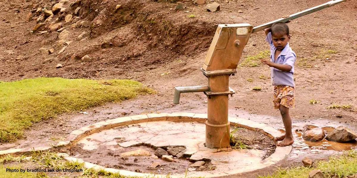 A boy at a dry water pump in India