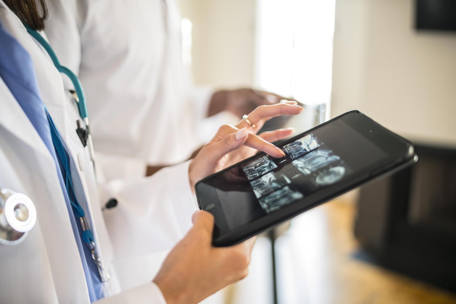 Doctor in hospital holding iPad With x-ray scans 