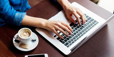 woman typing on laptop in coffee shop