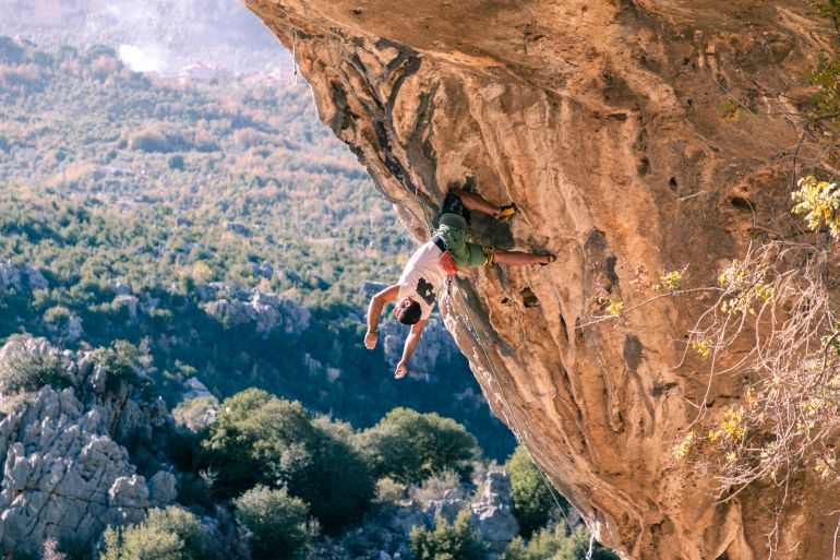 Eddy Kazi hangs off a rock face