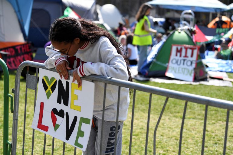 Massachusetts Institute of Technology student Ashley Williams, of Jamaica, hangs a sign on a barricade surrounding a protest encampment in support of Palestinians, during the ongoing conflict between Israel and the Palestinian Islamist group Hamas, at the Massachusetts Institute of Technology (MIT) campus in Cambridge, Massachusetts, U.S. April 28, 2024. REUTERS/Amanda Sabga