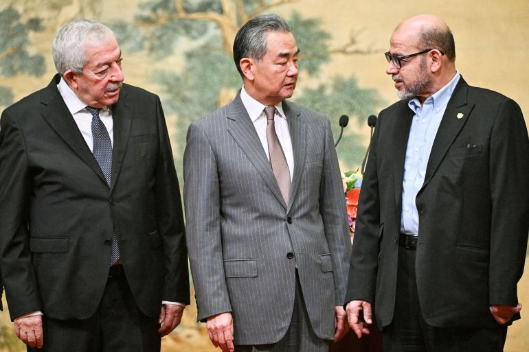 Mahmoud al-Aloul of Fatah, China's Foreign Minister Wang Yi, and Mousa Abu Marzouk of Hamas attend an event at the Diaoyutai State Guesthouse in Beijing on July 23, 2024 [Pedro Pardo/Pool via Reuters]