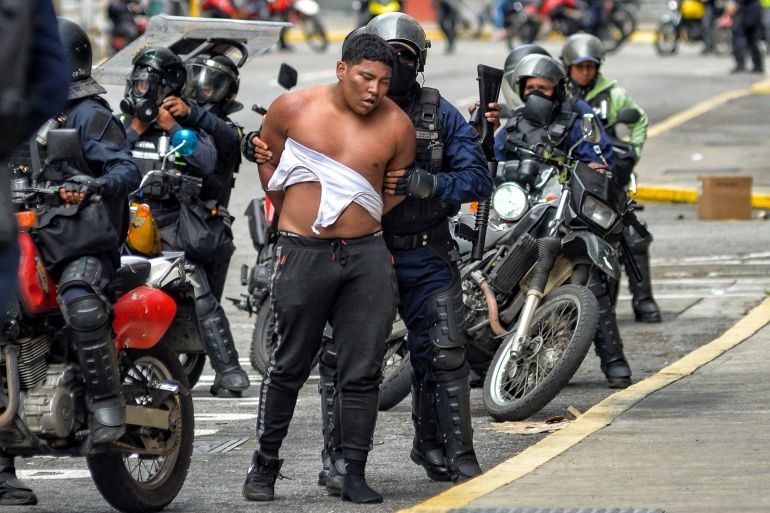 Police arrest a man during a demonstration called by the opposition in Caracas, Venezuela