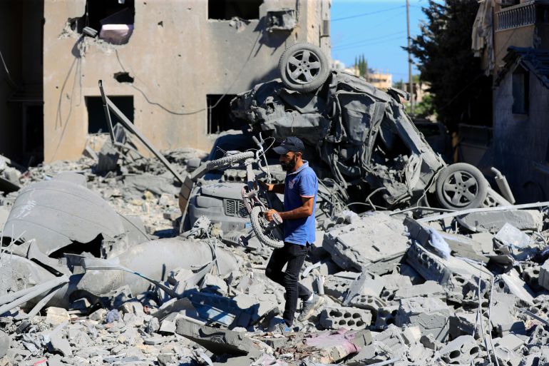 A man carries a damaged bicycle at the site of an Israeli air attack in Saksakieh, south Lebanon.