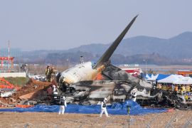 Firefighters and rescue team members work near the wreckage of a passenger plane at Muan International Airport in Muan, South Korea [Ahn Young-joon/AP Photo]