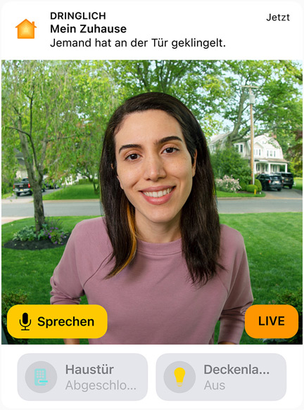 Die Ansicht einer Türklingel-Kamera mit einer Frau in einem rosa Sweatshirt. Das Display zeigt die Wörter „Sprechen“ und „Live“.