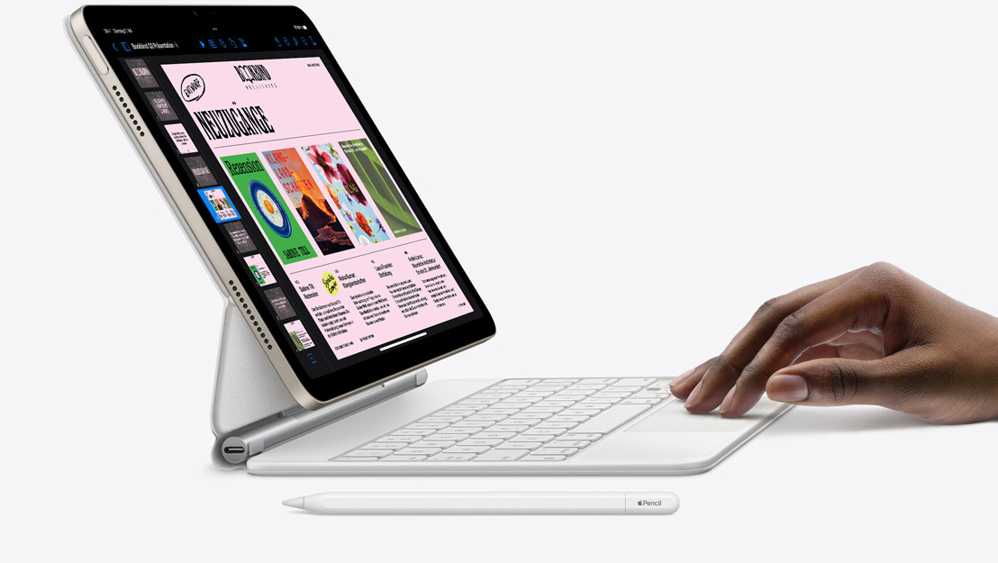 Seitenansicht eines iPad Air, auf dem die Keynote App zu sehen ist, befestigt am Magic Keyboard; eine Hand ruht auf dem Trackpad und ein Apple Pencil liegt in der Nähe.