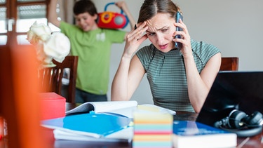 Frau arbeitet zuhause im Homeoffice mit Kind im Hintergrund | Bild: colourbox.com