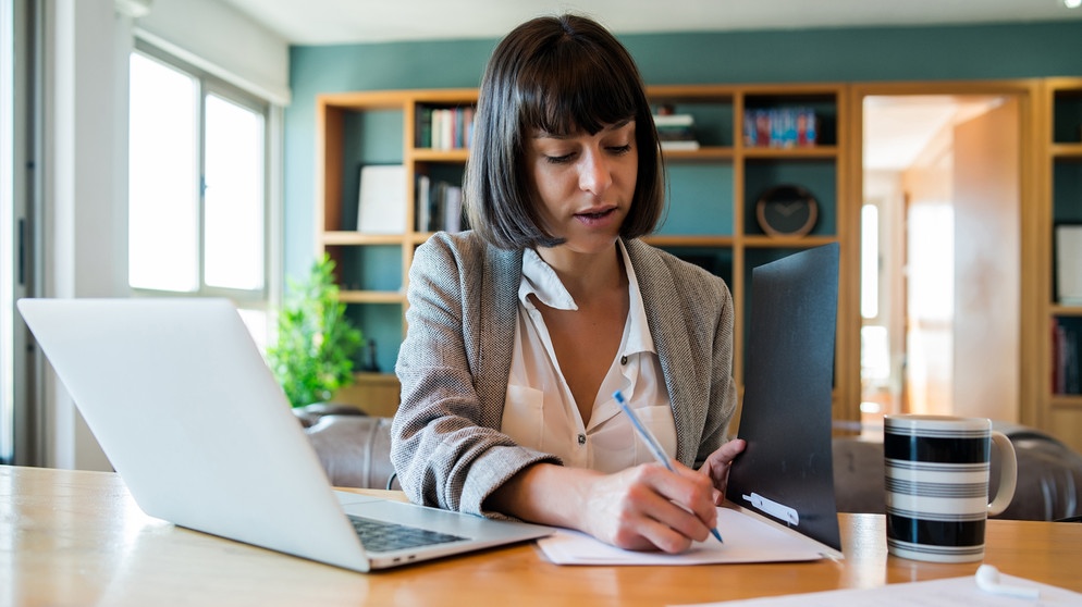 Frau im Homeoffice am Schreibtisch. Schadet es eurer Gesundheit, wenn ihr im Homeoffice arbeitet? Wir erklären Vor- und Nachteile vom Arbeiten zuhause und im Büro - und haben Tipps, wie ihr im Homeoffice gesund bleibt.  | Bild: colourbox.com