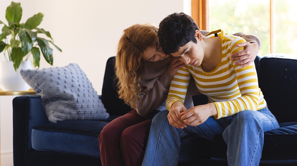 Eine Frau tröstet ihre Partnerin. Mit einer Depression zu leben, ist schwer. Auch, wenn es die des Partners oder der Partnerin ist. Wie ihr mit der Belastung in der Beziehung umgehen könnt. | Bild: picture alliance / Zoonar | Channel Partners