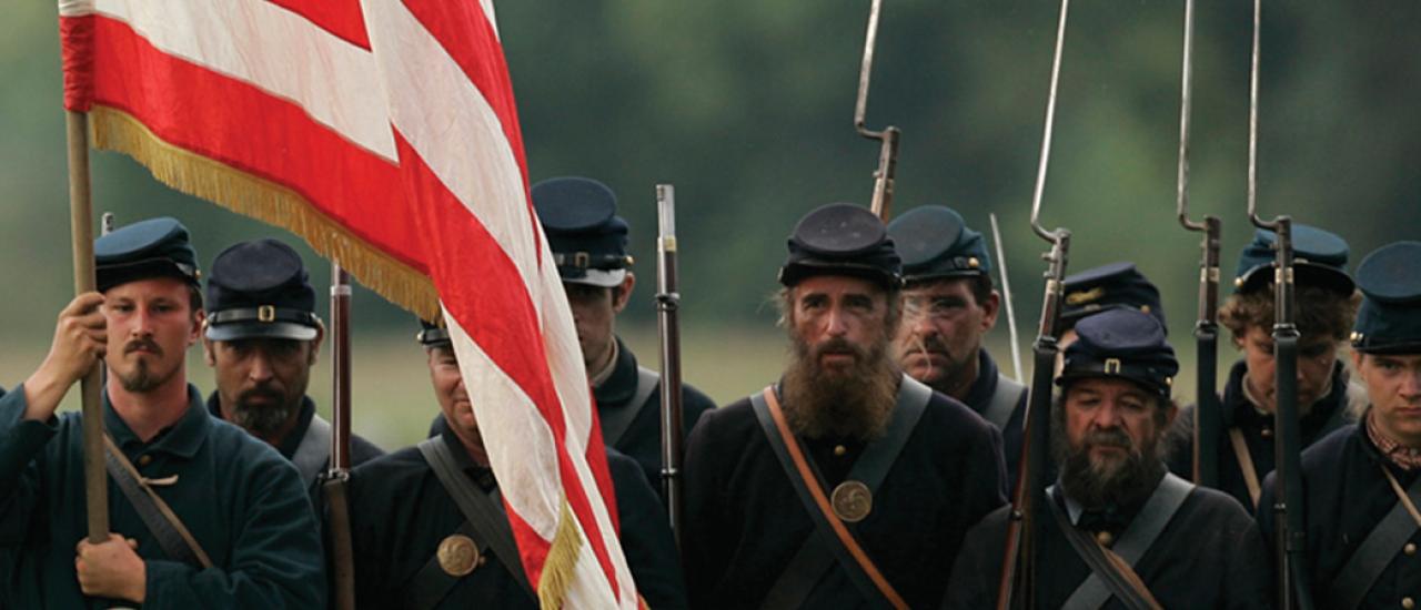 This is an image depicting a brigade of Union troops holding an American flag. 