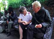 Uniformed Salvation Army officer talking to a homeless man