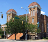 Red brick modern church building with towers at the two front corners