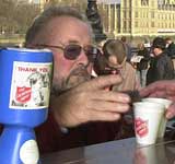 Man buying Salvation Army-branded cups over a counter, with a Salvation Army collection