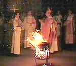 Worshippers stand around a charcoal burner