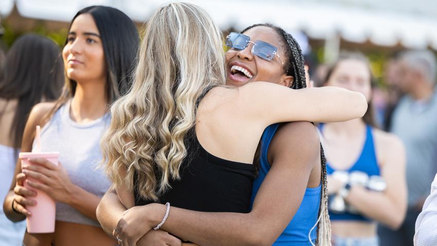 Two alumnae hugging and smiling