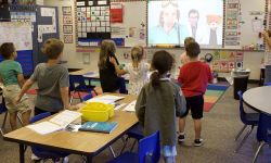 Young students looking at a screen in a classroom