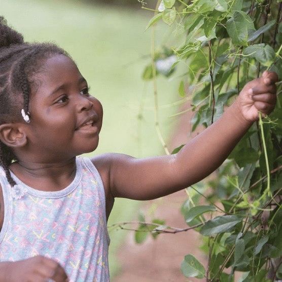 little girl smiling playing outside at daycare