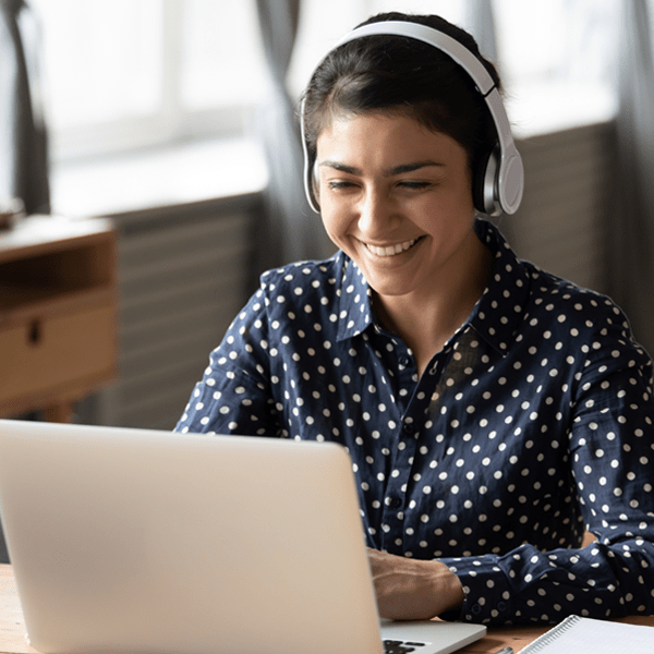 Women exploring educational family resources on her laptop with headphones