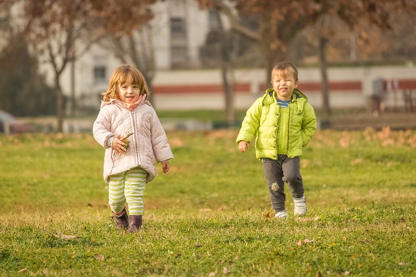 Two children running on the grass