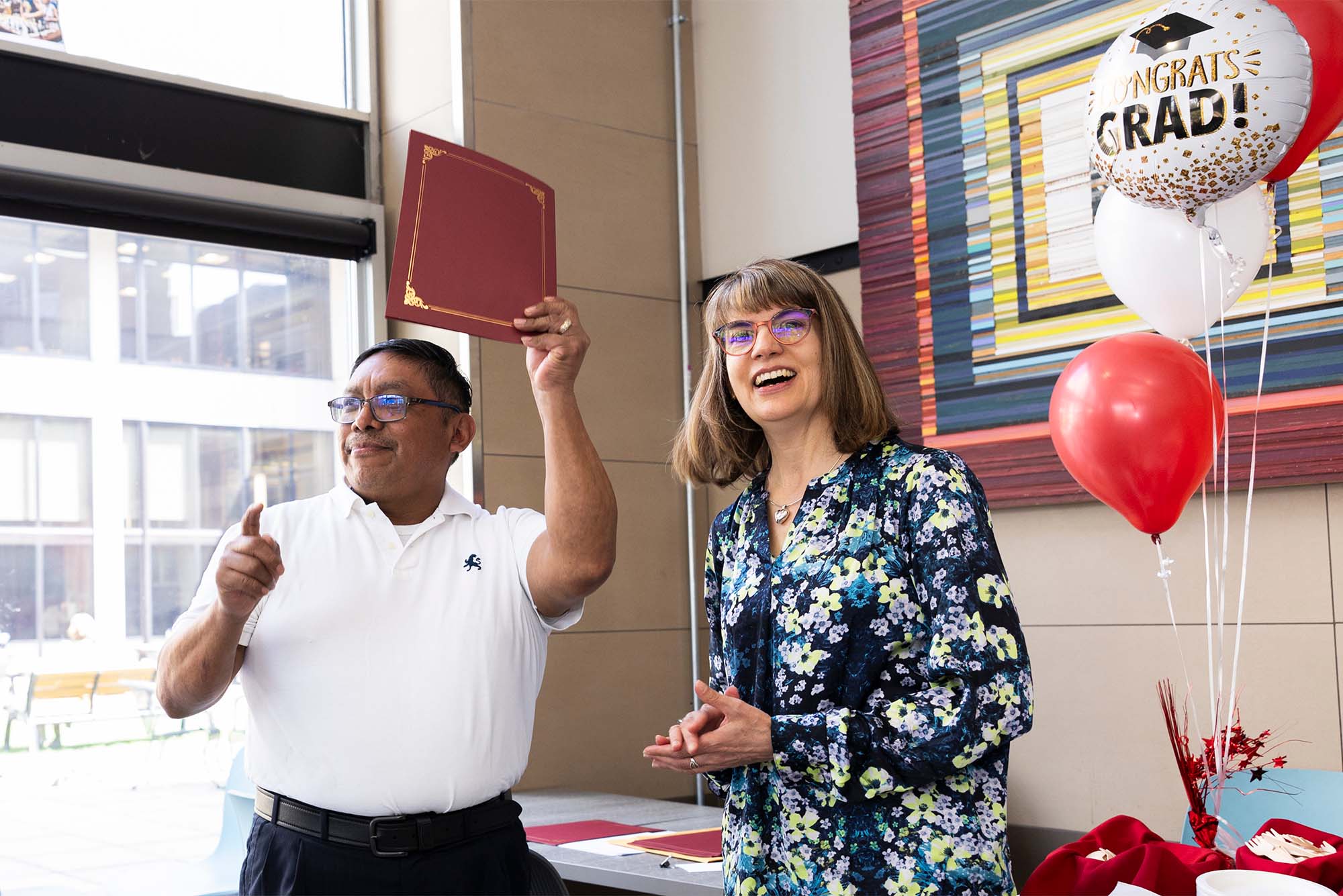 Photo: A man and a woman celebrating at a recent graduation ceremony for ESL grads at Boston University