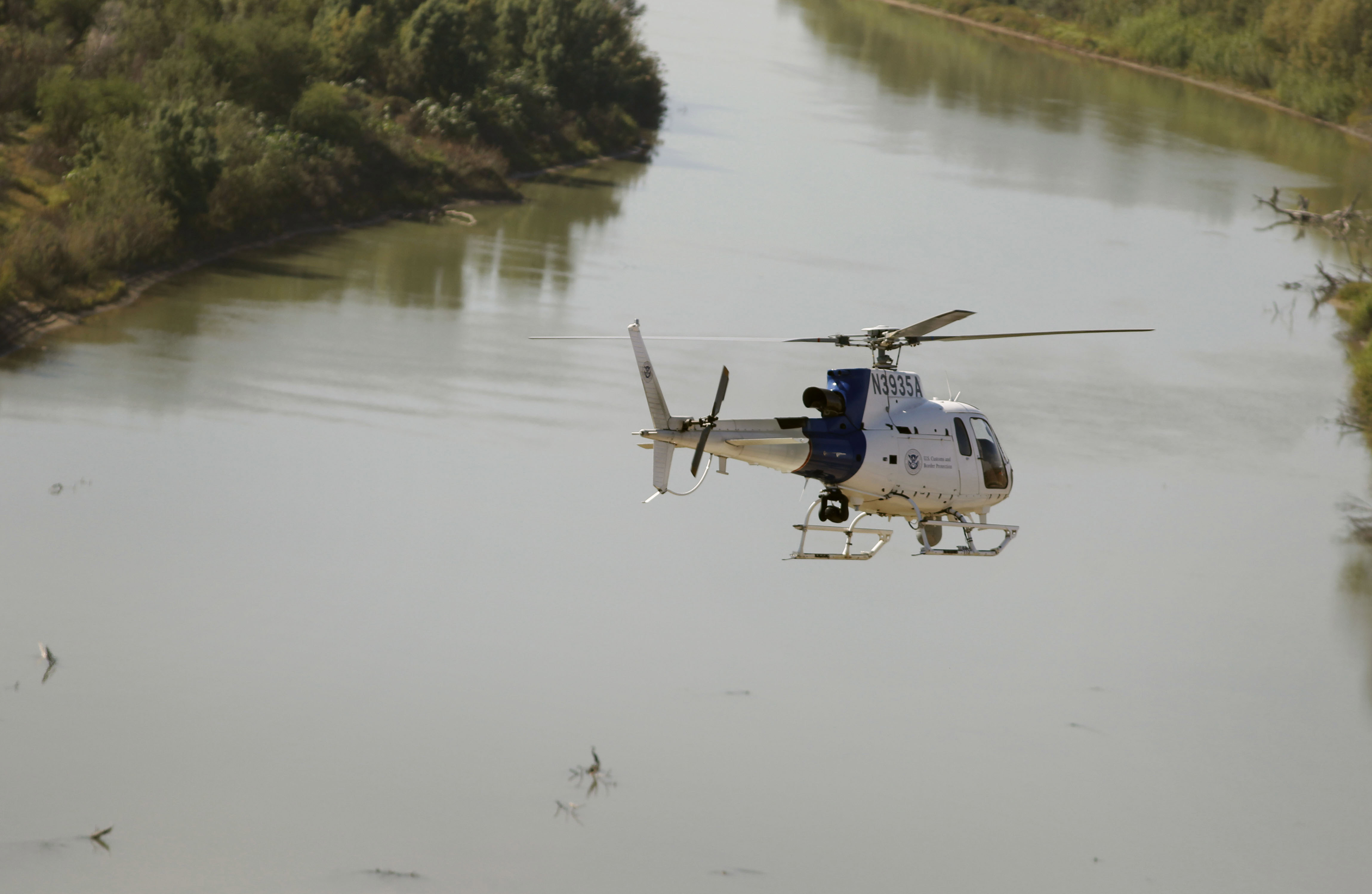 An Air and Marine Operations  AS350 crew flies over the Rio Grande River during a border security patrol near McAllen, Texas.