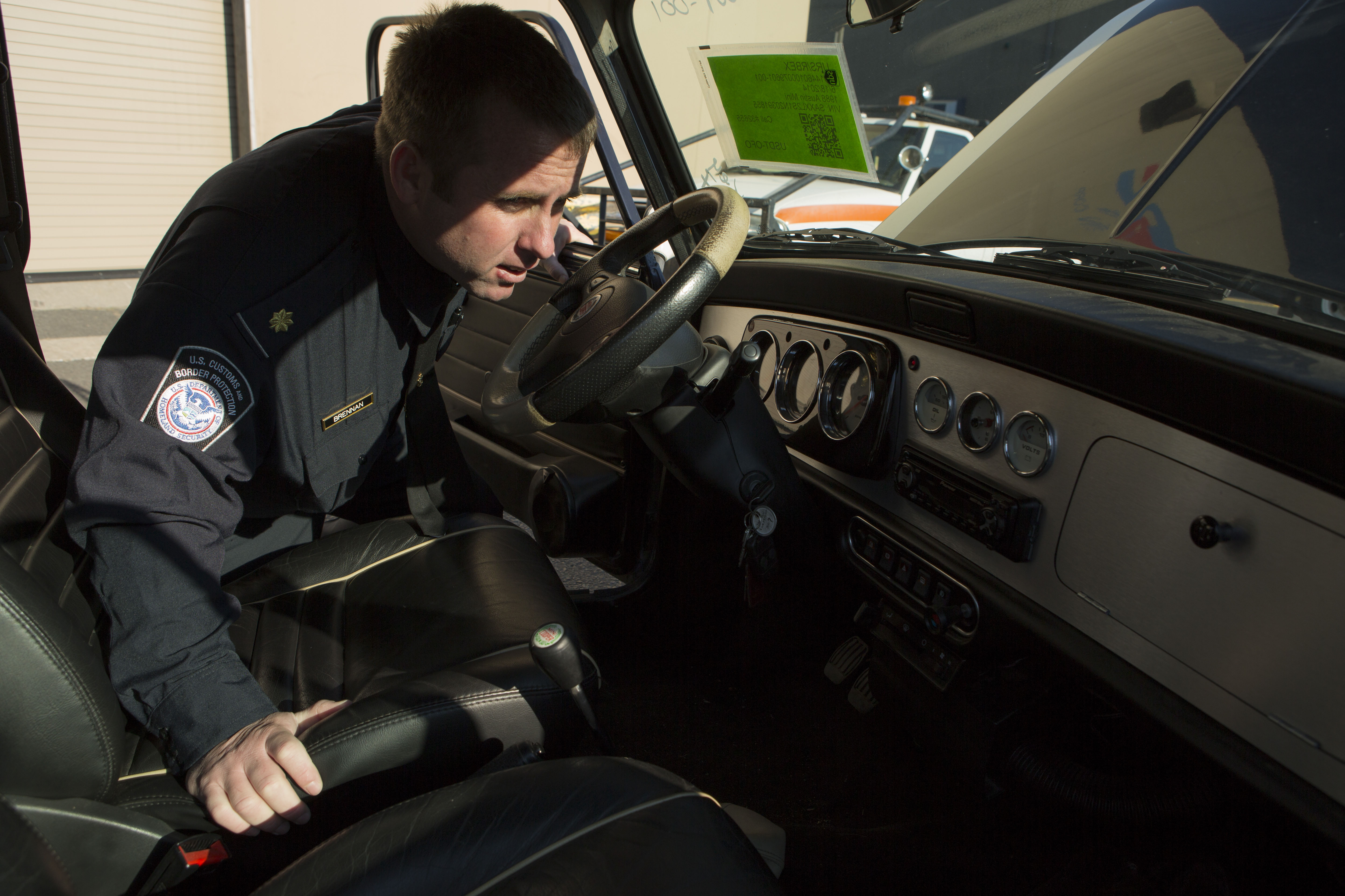 A Customs and Border Protection Officer inspects a Mini Cooper that arrived to Port Elizabeth NJ that had numerous violations associated with it related to importation. This vehicle will be destroyed as a result. Photo Credit: James Tourtellotte