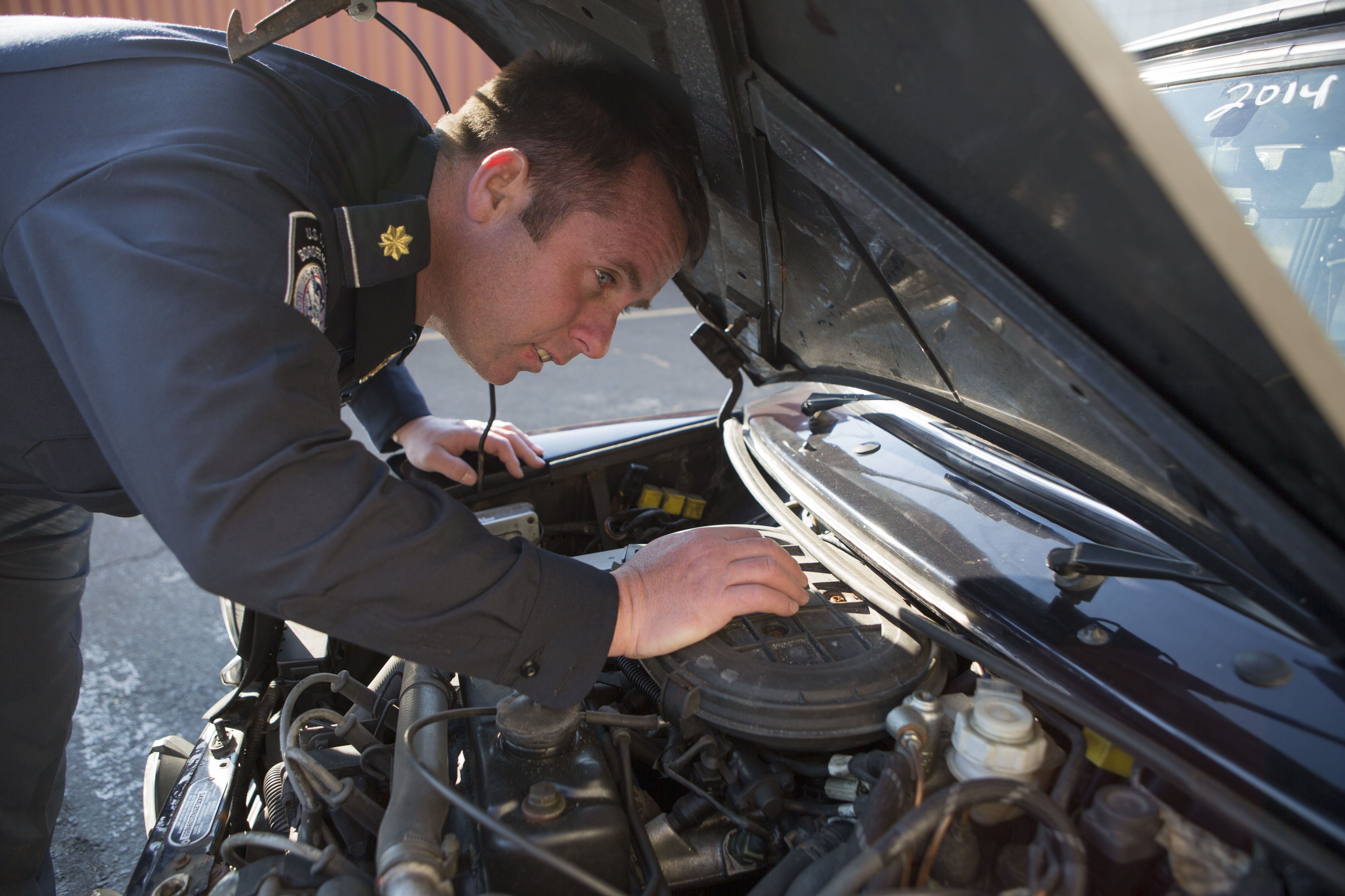 A Customs and Border Protection Officer inspects a Mini Cooper that arrived to Port Elizabeth NJ that had numerous violations associated with it related to importation. This vehicle will be destroyed as a result. Photo Credit: James Tourtellotte