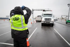 CBP officer gestures to the driver of a scanning vehicle as CBP conducts X-ray inspections.