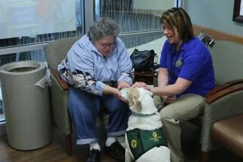 Maya Daniels and her dog Otay provide K-9 therapy to a woman