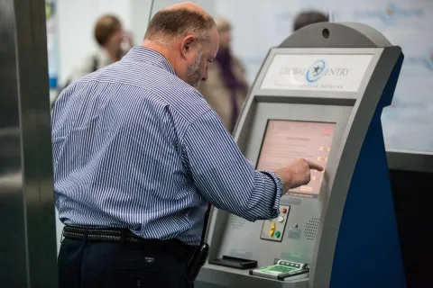 An arriving passenger uses a Global Entry kiosk.