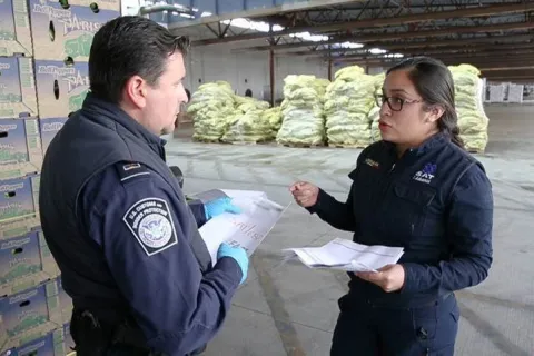 CBP Officers talking in front of cargo at a port of entry