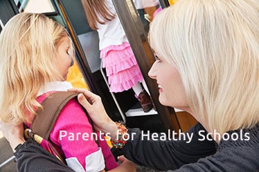 Mother Putting Backpack on Daughter at School Bus