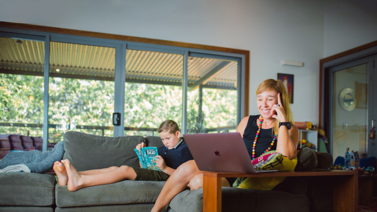 Parent working on computer and smiling