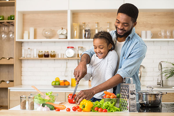 A father and child cutting vegetables