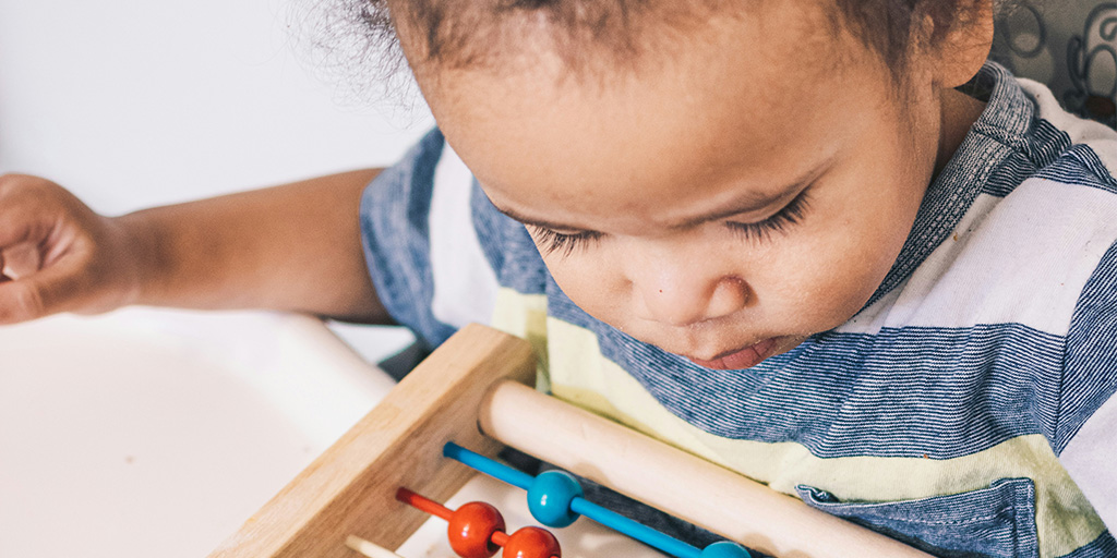 a young child plays with an abacus