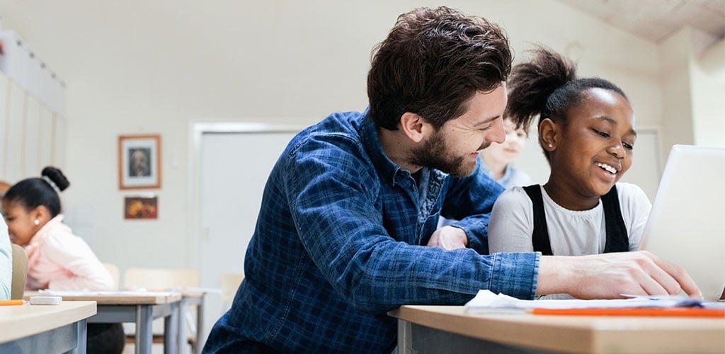 Un enseignant aide ses élèves à faire leurs devoirs.