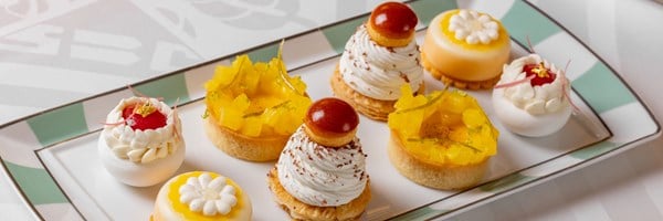 afternoon tea close up of pastries showing choux buns, tarts and meringue pastries