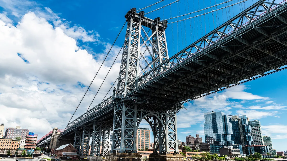 A view of a large suspension bridge over water from underneath.