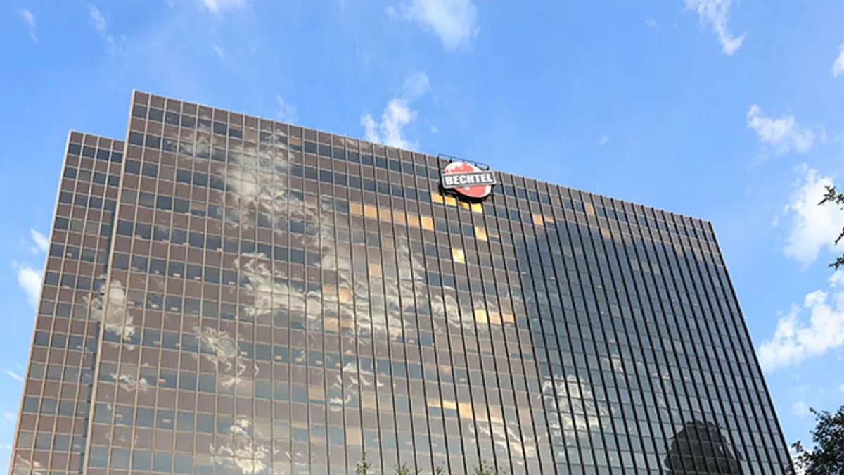 A tall building with the Bechtel logo on the top on a clear and sunny day.